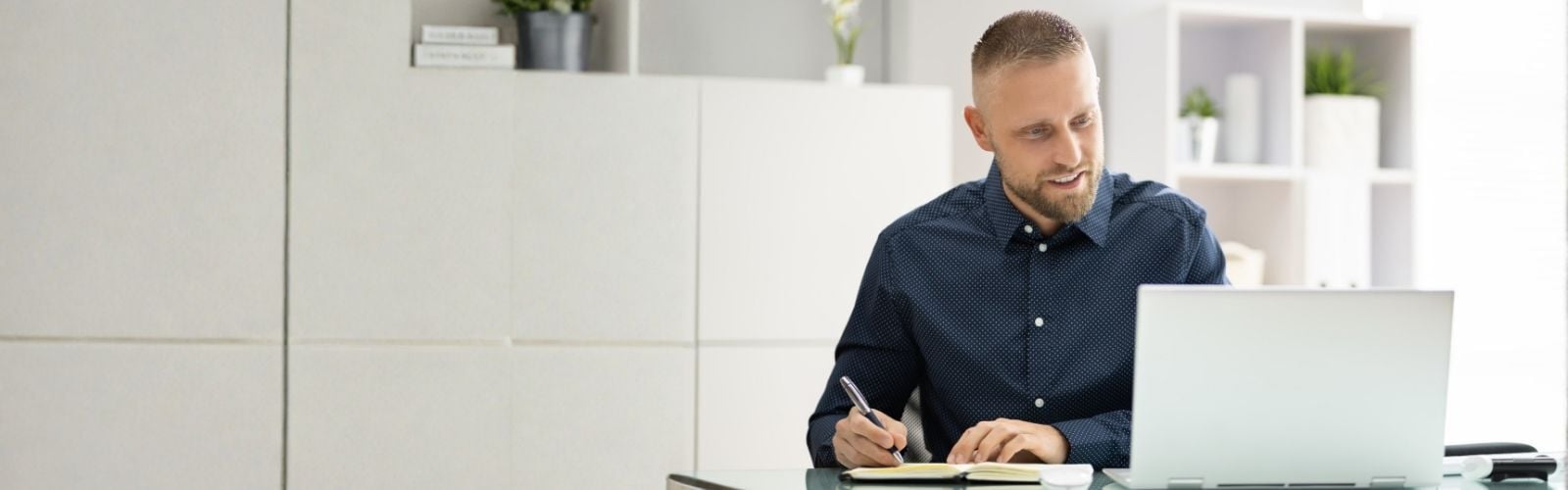 Mann sitzt am Rechner und schaut ein Webinar